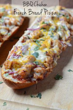 bread with meat and cheese on it sitting on a cutting board