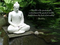 a buddha statue sitting on top of a wooden platform in the middle of a pond