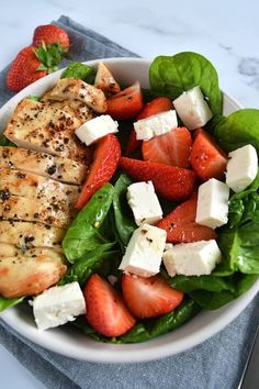 a salad with chicken, strawberries and feta cheese