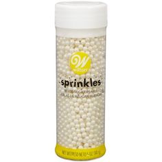 a bottle of sprinkles with white pearls in it on a white background