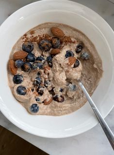 a bowl of oatmeal with blueberries and almonds