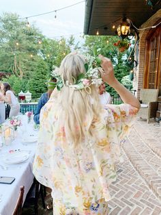 a woman standing in front of a table with flowers on it