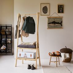 a room with clothes hanging on the rack and shoes sitting on the floor next to it