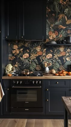 a kitchen with black cabinets and floral wallpaper on the backsplash is shown