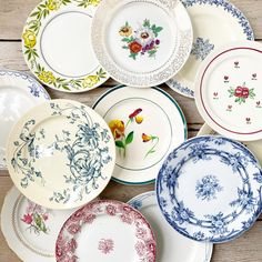 many plates are stacked on top of each other with flowers painted on them and one is empty