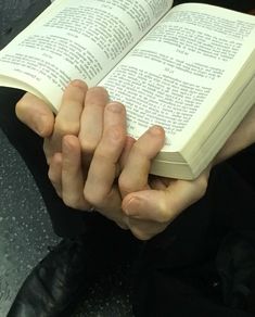 a person holding an open book in their hands