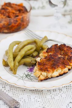 a white plate topped with food next to green beans