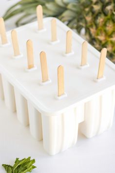 toothpicks are lined up on a tray next to a pineapple