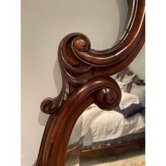 a large wooden mirror sitting on top of a bed