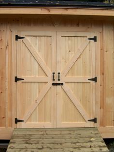 a large wooden garage with two doors open