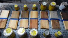 several different types of paint sitting on top of a pallet with wooden planks