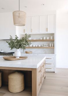 a kitchen island with two stools and a potted plant on it in the center