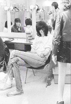 a group of people sitting in front of a dressing room mirror looking at their hair