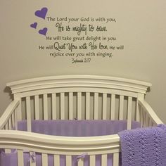 a baby crib with a purple blanket and wall decal above it that says, the lord your god is with you