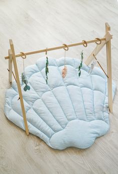 an infant's play mat is hanging on a wooden frame with clothes pins attached to it