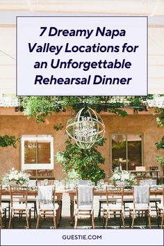 a dining room table with chairs and chandelier hanging from the ceiling, surrounded by greenery