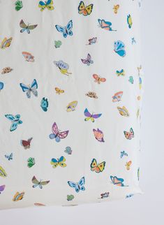 a white sheet with colorful butterflies on it and the bottom half is folded up to reveal an image