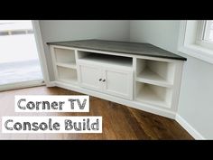 the corner tv console build is shown in this room with hardwood floors and white walls