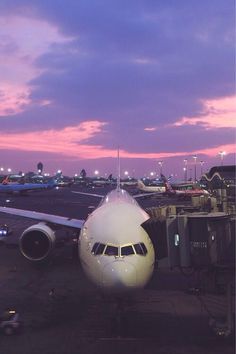 an airplane sitting on the tarmac at dusk