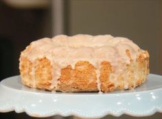 a frosted cake sitting on top of a white cake platter with icing