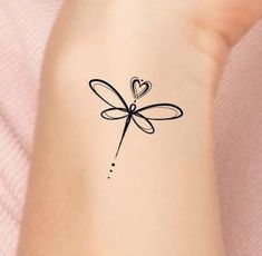 a woman's arm with a tattoo on it that has a heart and a dragonfly