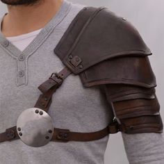 a man wearing a leather armor with a metal ball attached to his chest