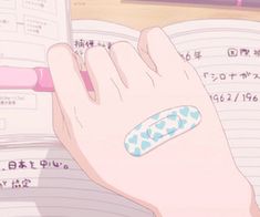 a person's hand holding a pen and writing on a notebook with an eraser