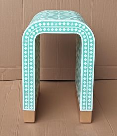 a small blue and white stool sitting in front of a cardboard box on the floor