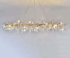 a chandelier made out of branches and glass beads hanging from it's ceiling