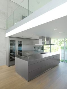 an empty kitchen with stainless steel appliances and glass doors leading to the upper floor area