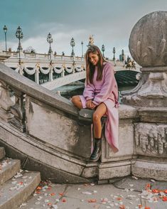 a woman sitting on top of a stone staircase