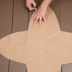 a person cutting out a cardboard star on the floor