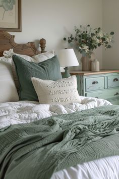 a bed with green and white pillows on it