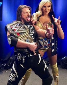 two people dressed in wrestling gear posing for the camera with one holding his arm around the other's shoulder