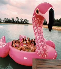 a group of women sitting on top of an inflatable flamingo