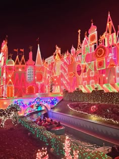 an elaborately lit castle with lots of lights on it's sides at night