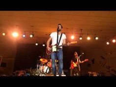 a man standing on top of a stage holding a guitar