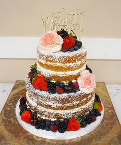 a multi layer cake with berries and strawberries on top