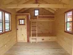 the inside of a small wooden cabin with windows and ladders on each side of the door