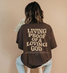 Introducing our new "Living Proof of a Loving God " t-shirt, a perfect expression of faith and style. This Christian shirt features a timeless design and a powerful message. This shirt is not only a fashionable choice but also a meaningful one. It serves as a reminder of the saving grace of Jesus Christ and the hope and redemption that comes with it. It's a great way to boldly express your faith and share your beliefs with others! ⁑ F U N ⁑ F A C T S ⁑ ☼ Unisex Adult Sizes ☼ 100% Cotton ☼ Washer Brown Bible Verse, Jesus Clothes, Christian Shirts Designs, Christian Streetwear, Aesthetic Christian, Church Shirt, Loving God, Christian Men, Jesus Tshirts