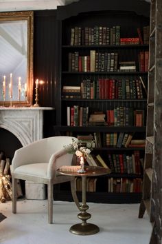 a living room filled with furniture and a fire place next to a bookshelf