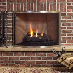 a fire place in a brick fireplace with logs on the side and an open flame