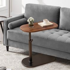 a gray couch with a wooden table on it