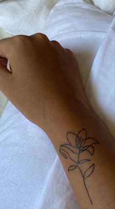 a person's arm with a flower tattoo on the left side of their arm