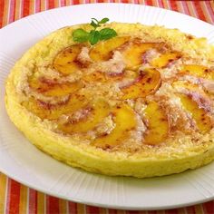 a white plate topped with an omelet covered in bacon and pineapple topping