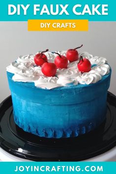 a blue cake with white frosting and cherries on top, sitting on a black plate