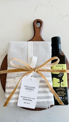 a wooden cutting board with a bottle of lotion on it and a wrapped gift