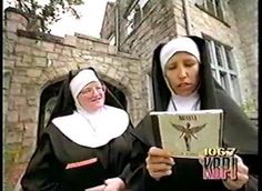 two women dressed in nun costumes are looking at a book