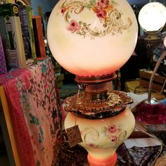 a lamp that is sitting on top of a table next to a pile of books