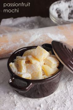 a brown bowl filled with food on top of a white counter next to a wooden spoon